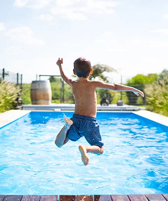 dziecko skaczące do basenu